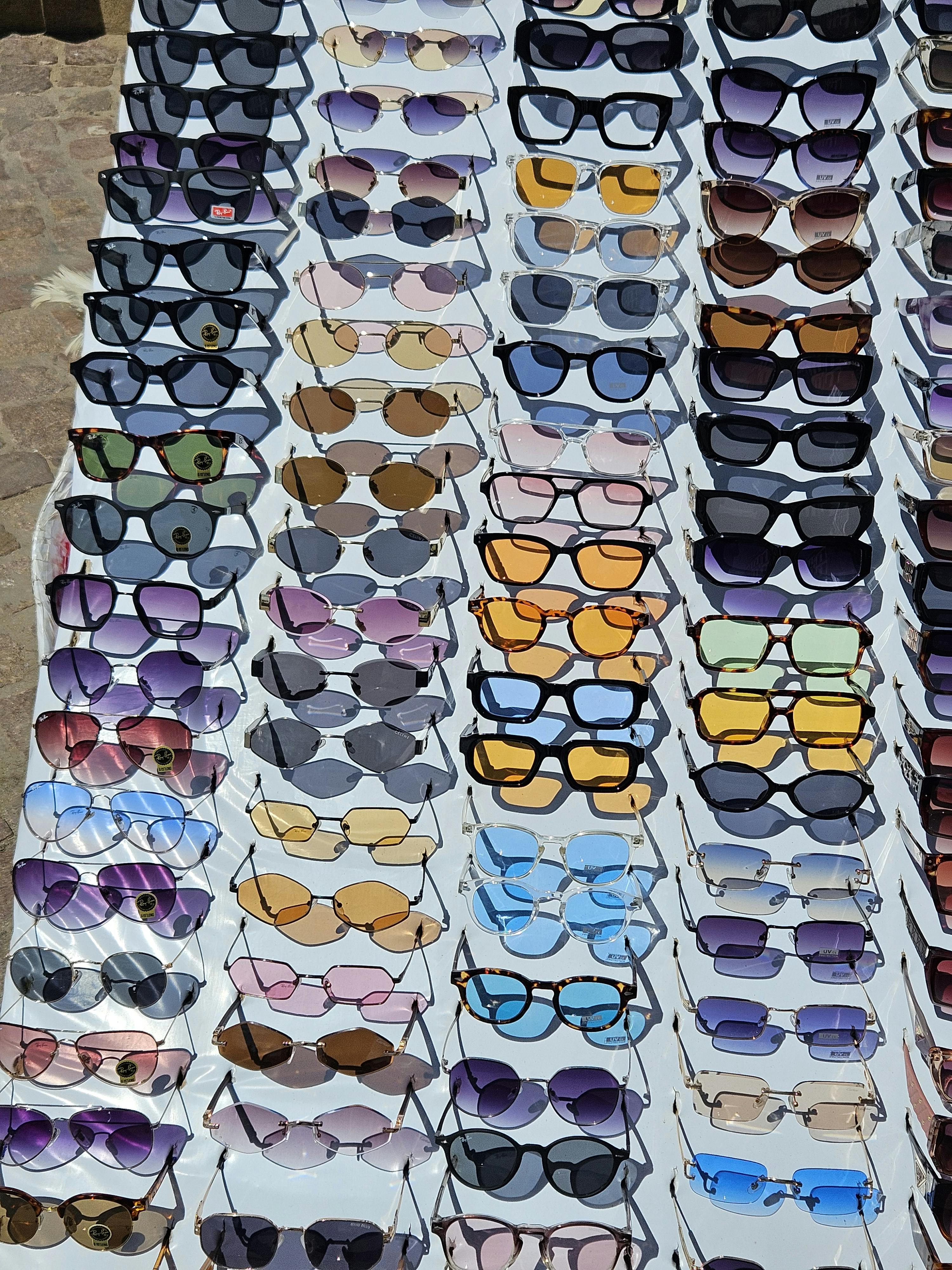 Several pairs of sunglasses with different colored lenses arranged on a surface