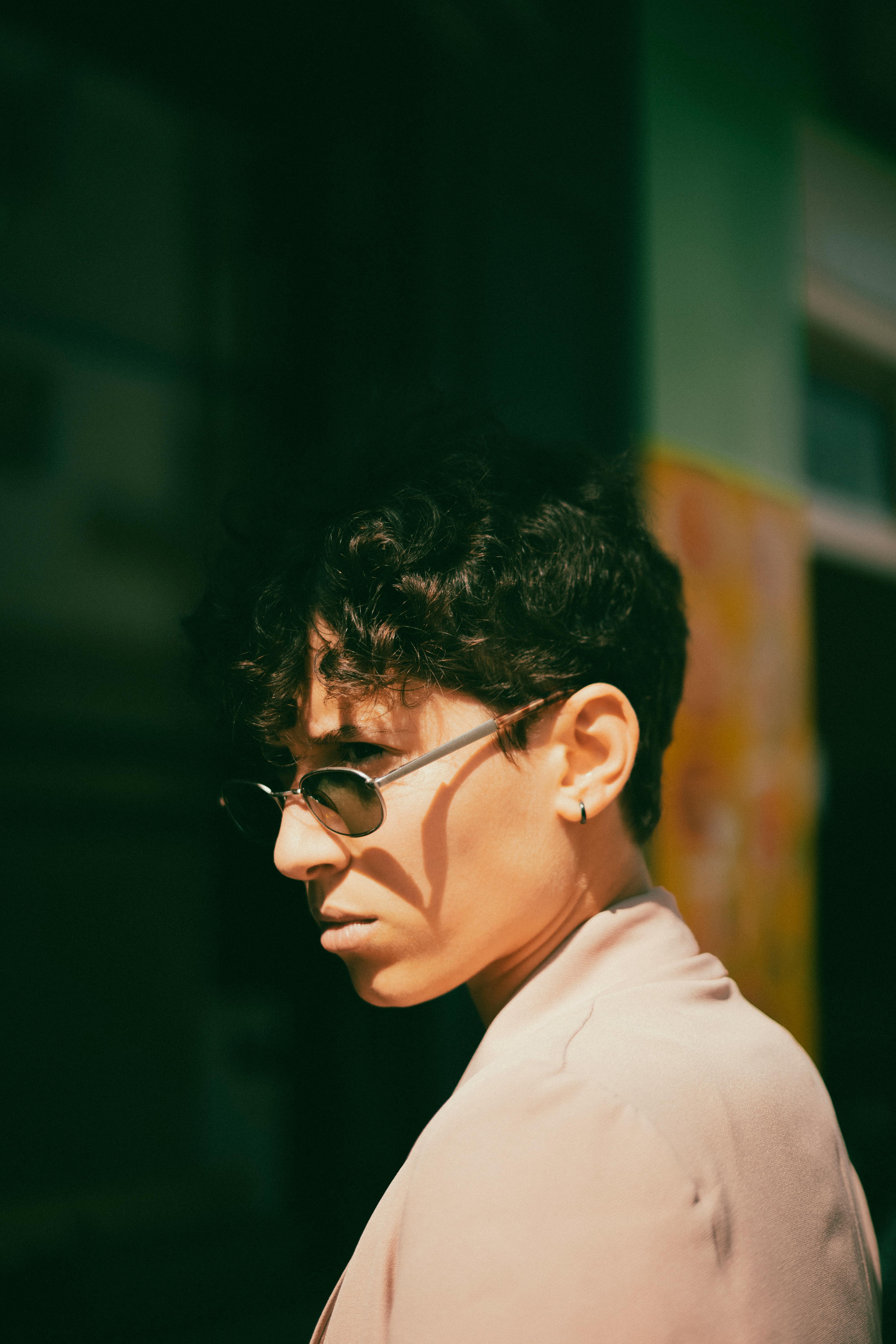 Person from the side wearing distinctive sunglasses, street photography style